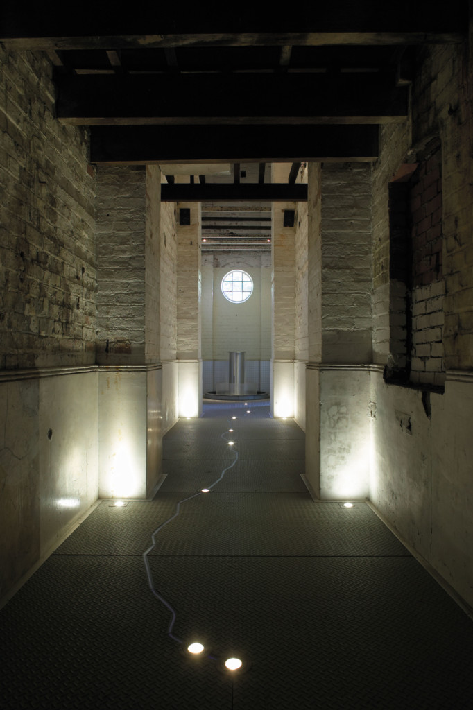 Dark interior corridor, lit by floor lights, at No 1 Pump Station in Mundaring.